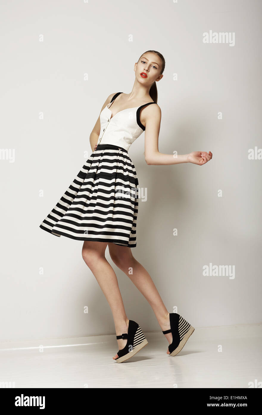 Fashion Style. Happy Young Shopper in Contrast Striped Grey Skirt. Movement Stock Photo