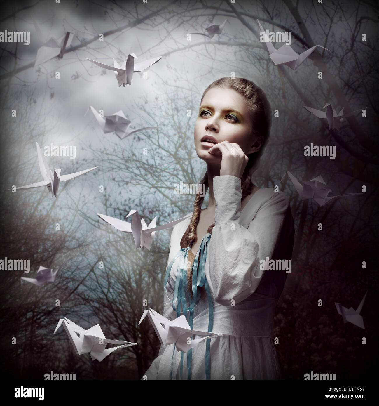 Inspiration. Woman with Flying White Origami Swans in Dark Mystic Forest Stock Photo