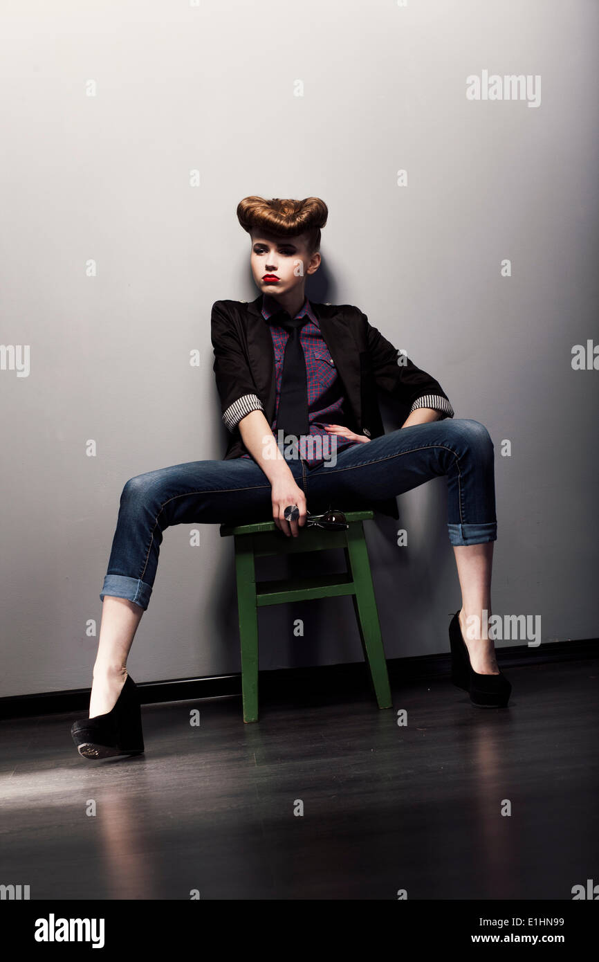 Pin up retro woman sitting in jeans and stylish jacket. Bright hairstyle  Stock Photo - Alamy