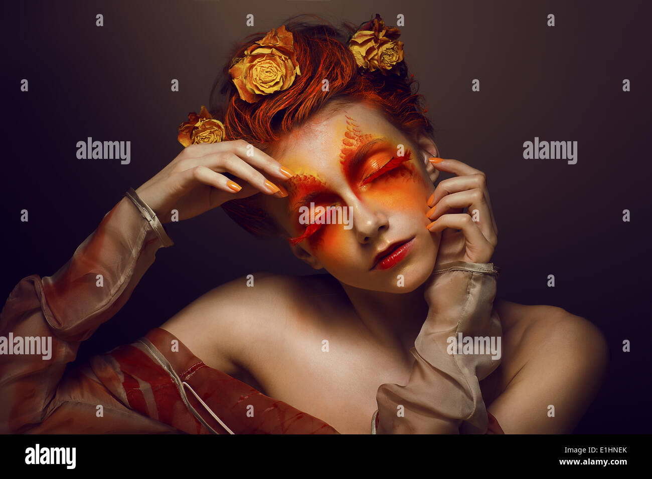 Bodyart. Imagination. Artistic Woman with Red - Gold Makeup and Flowers. Coloring Stock Photo
