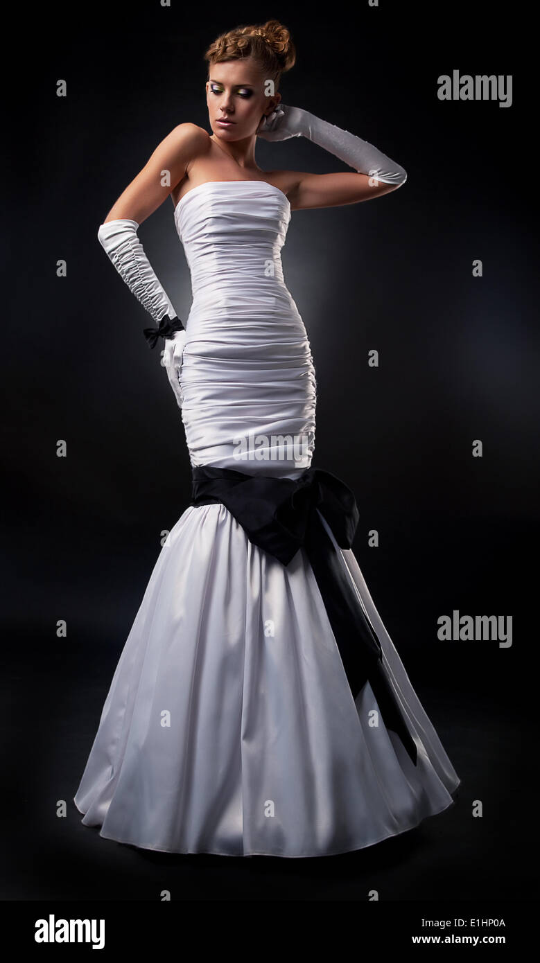 Bride blonde in white wedding long dress and gloves on podium standing ...