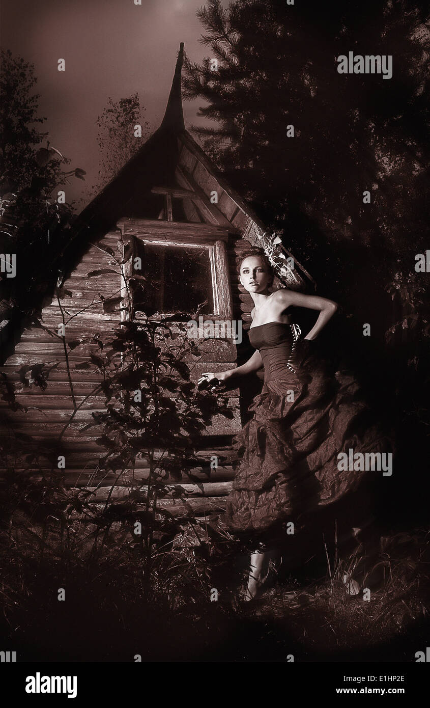 Night scenic - beautiful fairy walking along wooden hut black and white photo Stock Photo