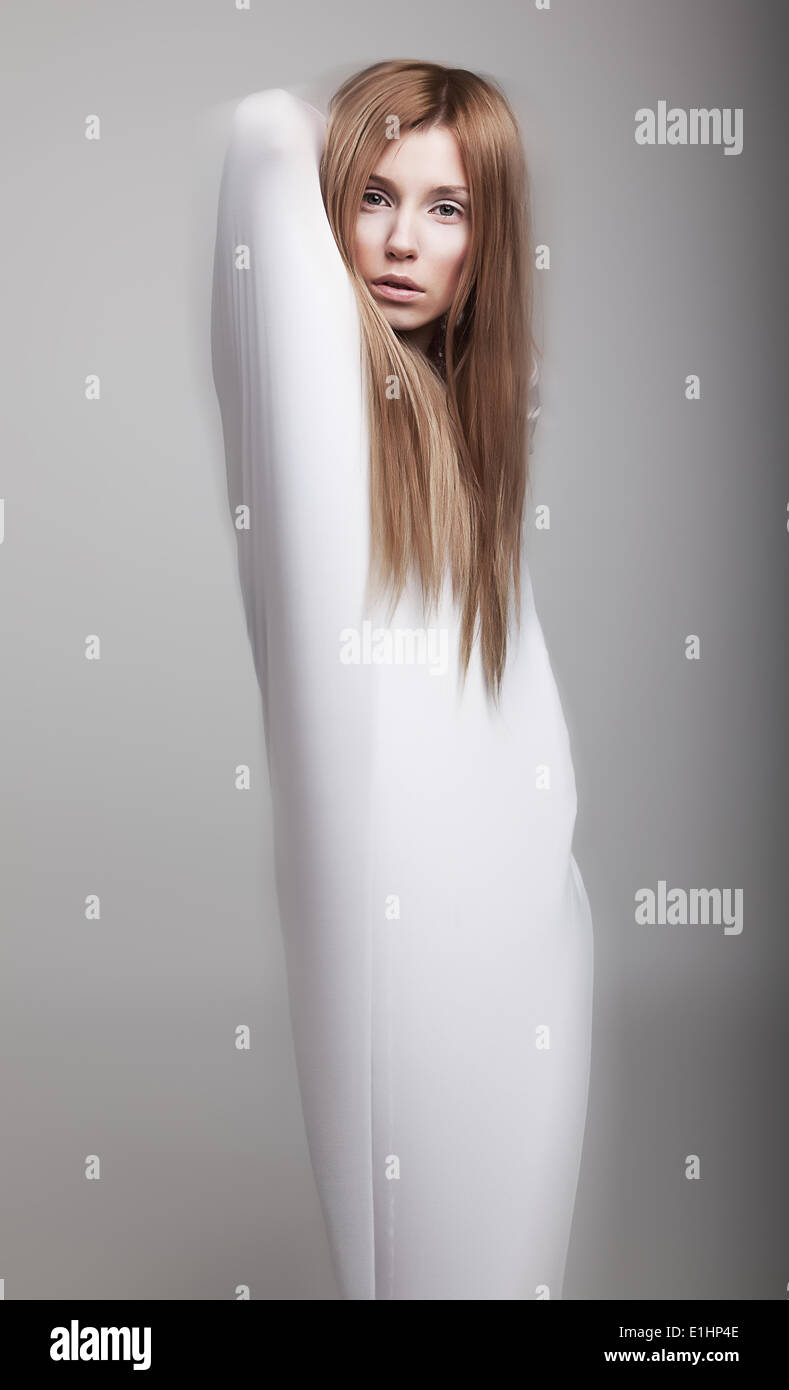 Graceful female silhouette in white clothes looks like ghost - studio shot. Series of photos Stock Photo