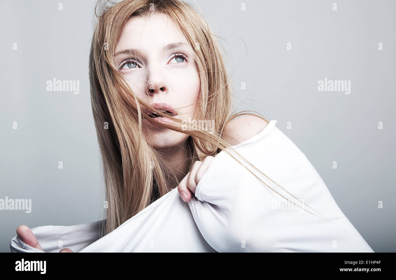 Danger - worried petty female blond hair in white cloth. No make up - series of photos Stock Photo