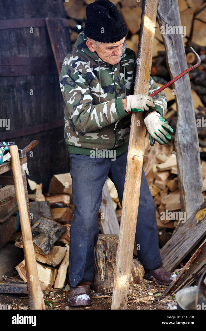 Senior man carpenter pulling nails out of a wood planck outdoor Stock ...