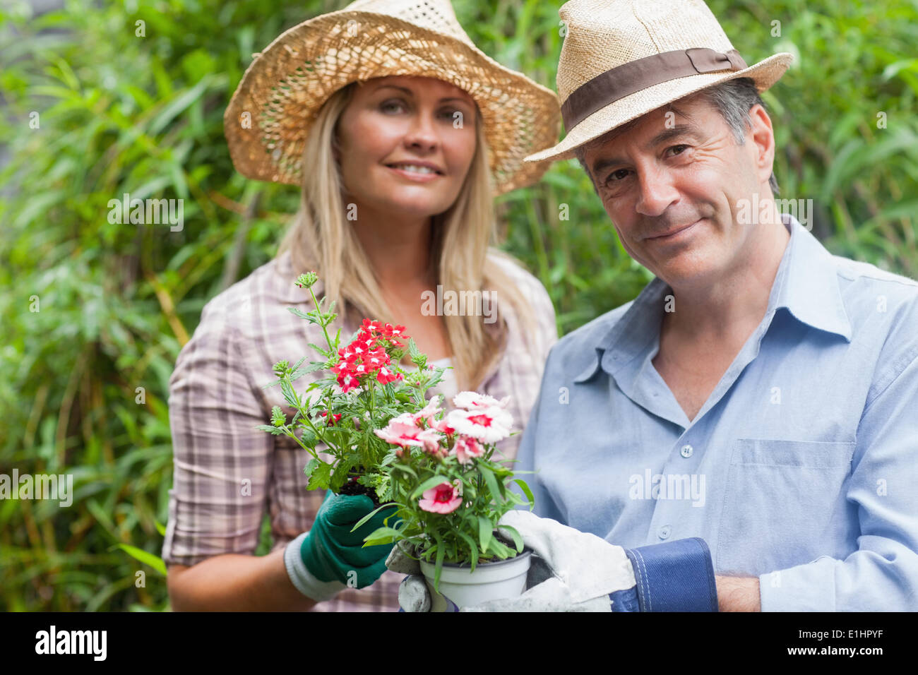 Blonde woman and man holding potted plant Stock Photo - Alamy
