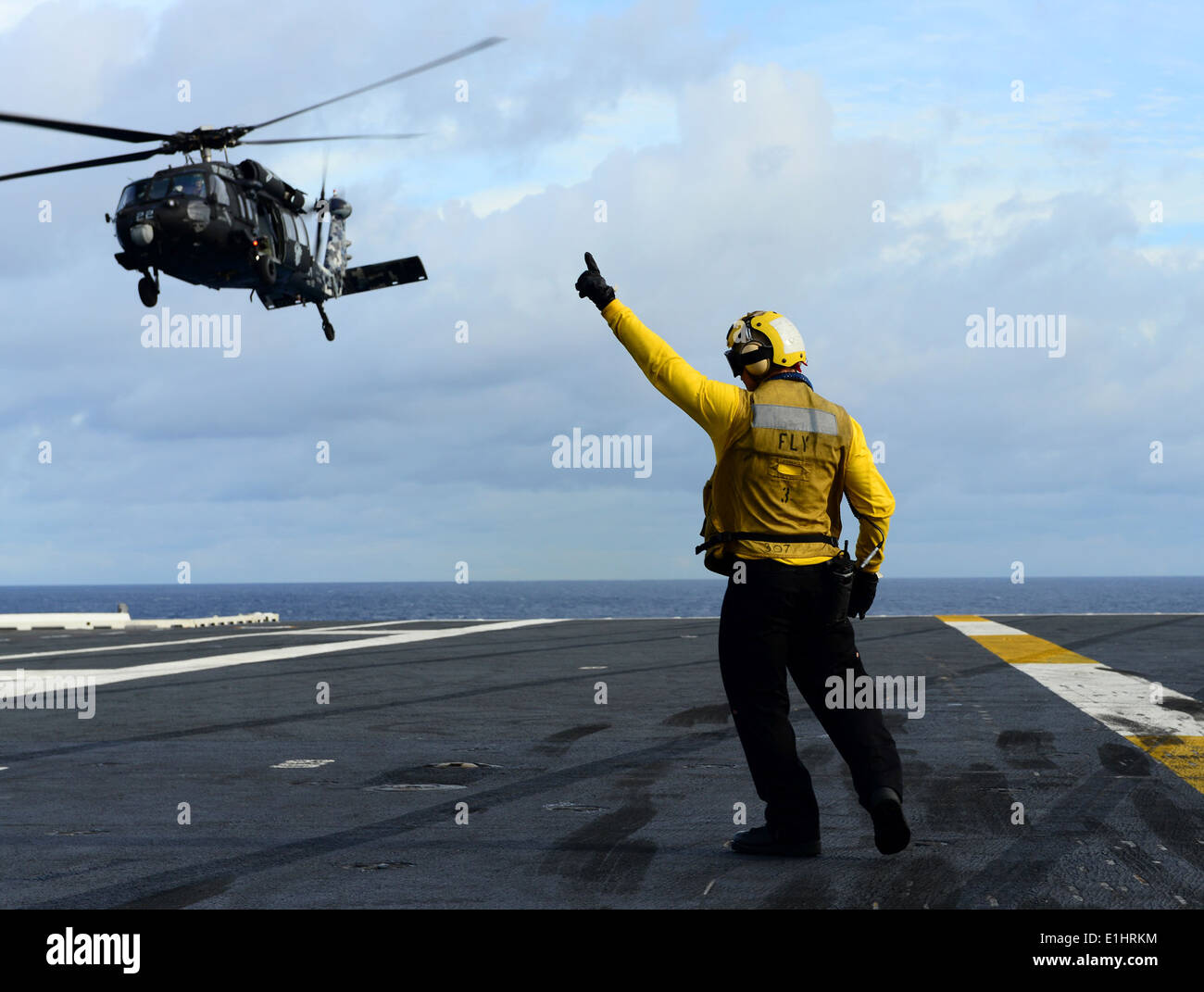 U.S. Navy Aviation Boatswain's Mate (Handling) 3rd Class Joshua Rabarabrokate directs an MH60S