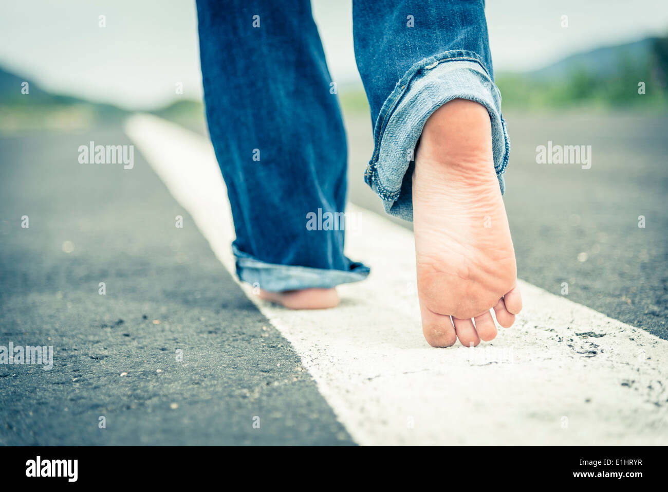 girl walking barefoot in the street