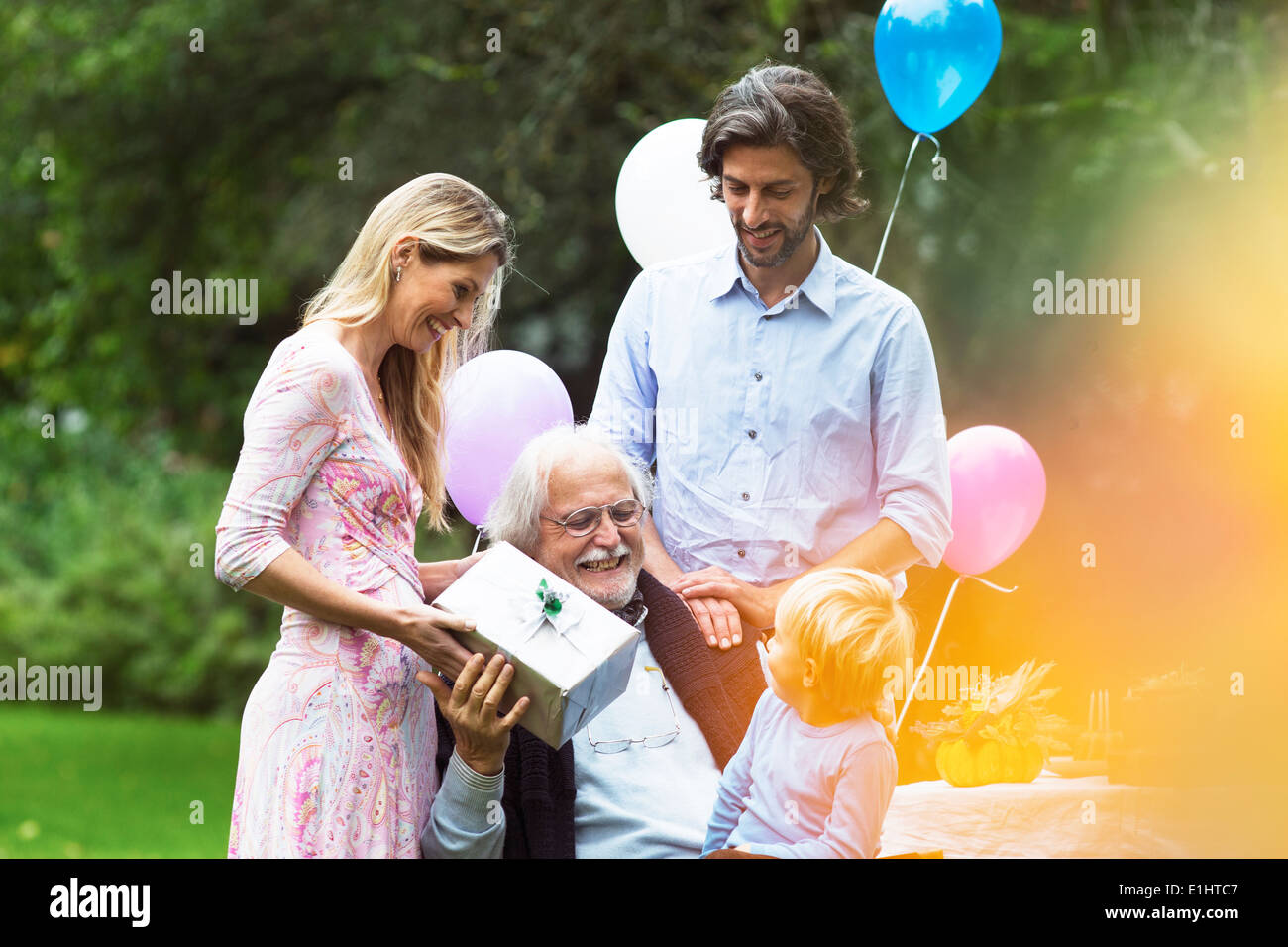 Grandfather receiving gifts on birthday party in garden Stock Photo Alamy