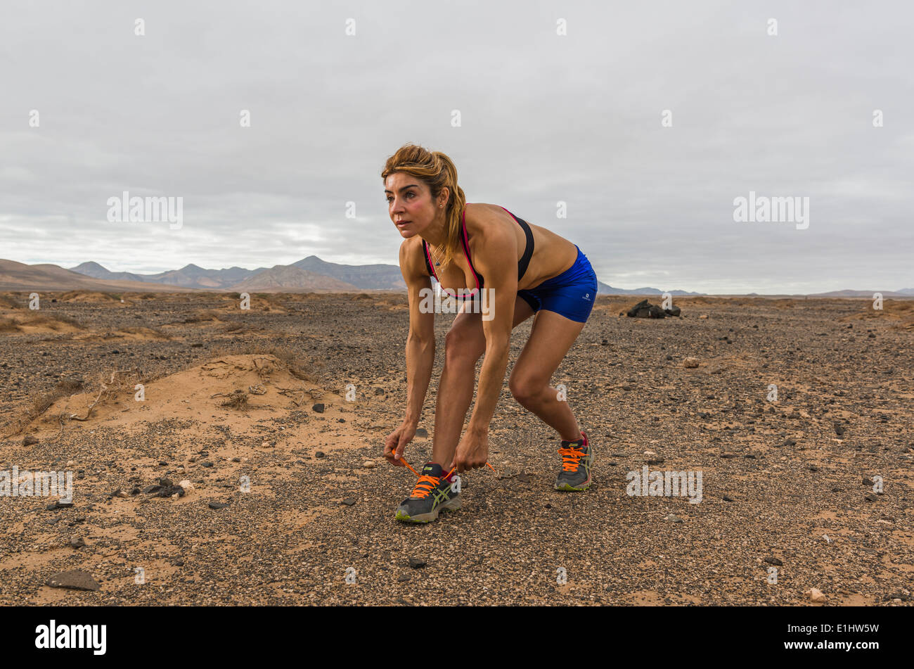 Woman tying her running shoes. Fuerteventura, Canary Islands, Spain, Europe. Stock Photo