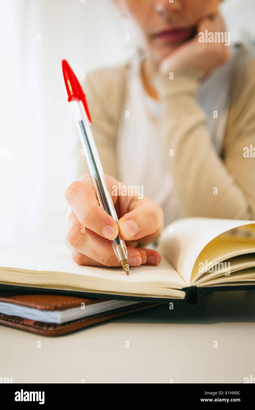 Woman writing down something with ball-pen, detail Stock Photo