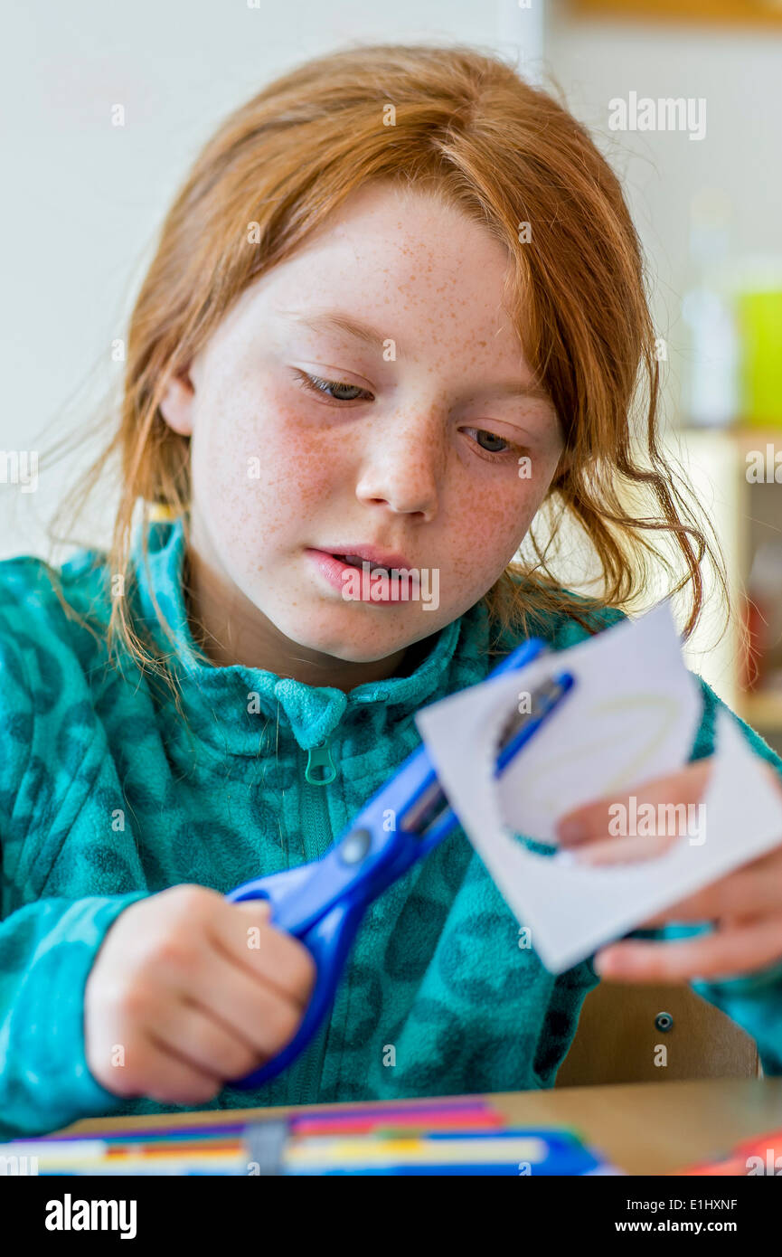 red-haired schoolgirl in the classroom Stock Photo