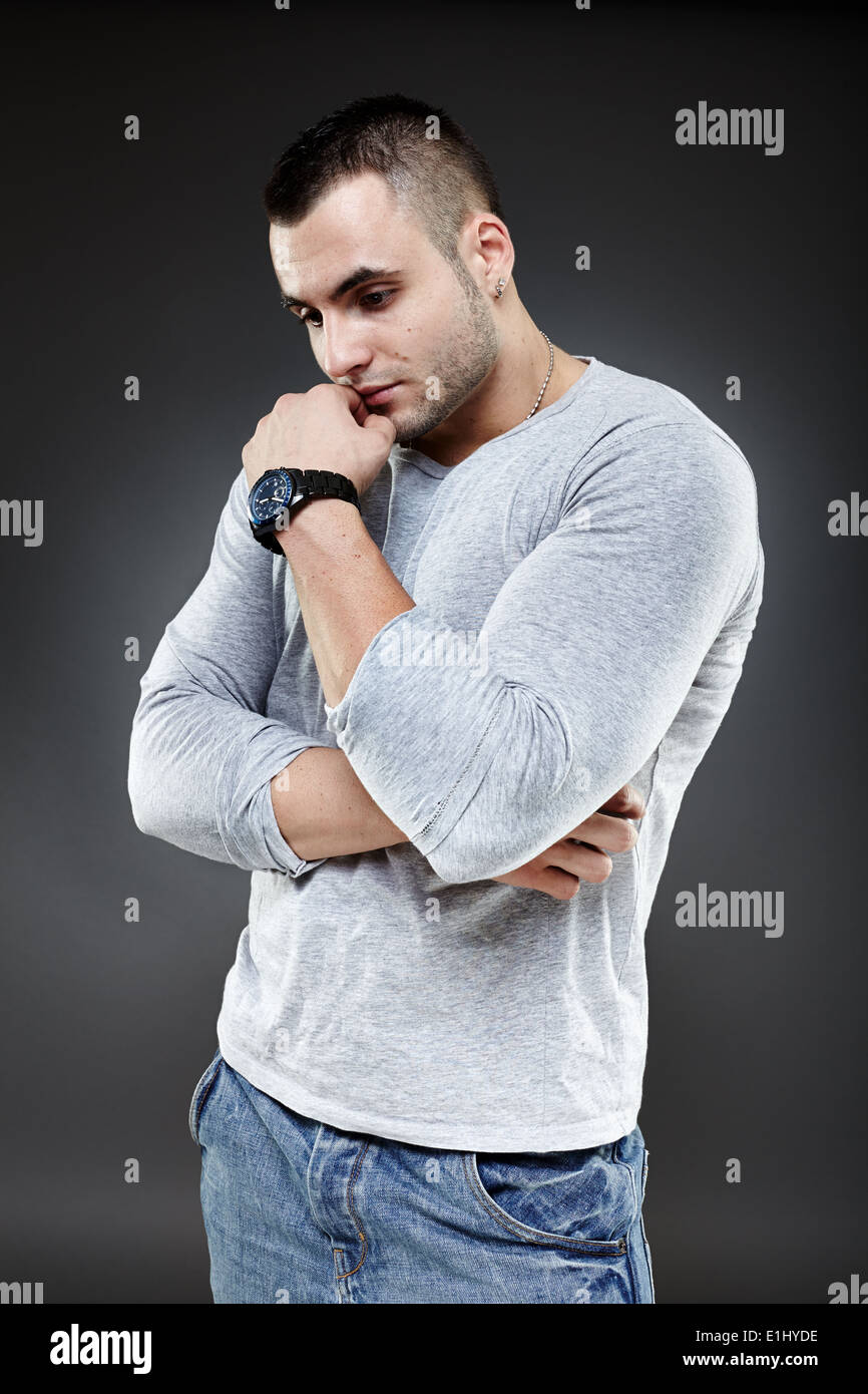 Portrait of a pensive young man over gray background Stock Photo - Alamy