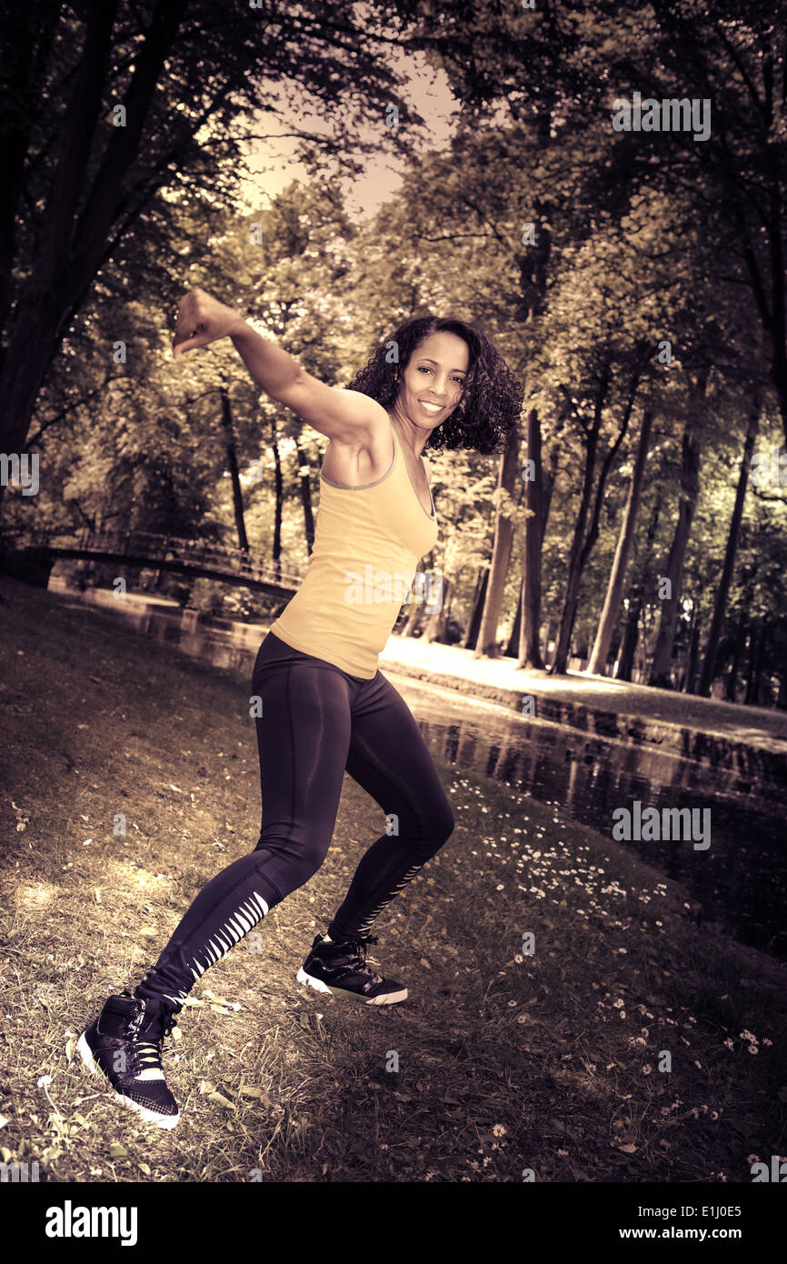 woman dancing the new fitness dance called zumba or aerobics in an old park Stock Photo