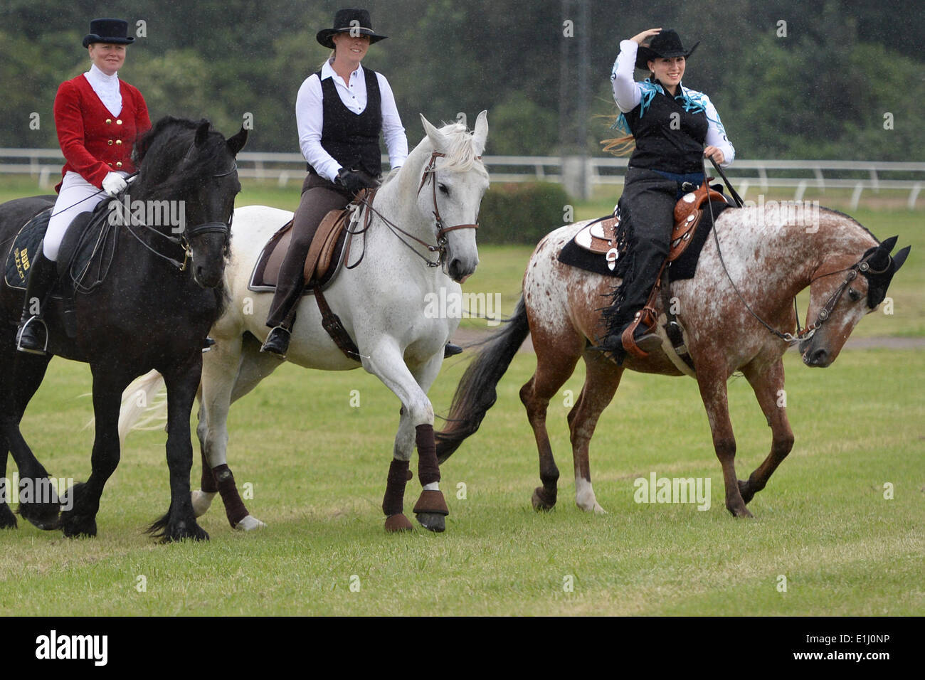 Frisian stallion Ebe with rider Susanne Fischer-Froehlich (L-R), Andalusia gray horse Luna with rider Petra Tinedo Moreno and American Appaloosa stud RR Moonlight Casey with rider Yara Deeb ride during a photocall for Equitana Open Air at the Galopprennbahn in Neuss, Germany, 05 June 2014. The equestrian festival 'Equitana Open Air 2014' with almost 200 events and 50 breeds of horse takes place from 13 until 15 June 2014. Photo: MATTHIAS BALK/dpa Stock Photo