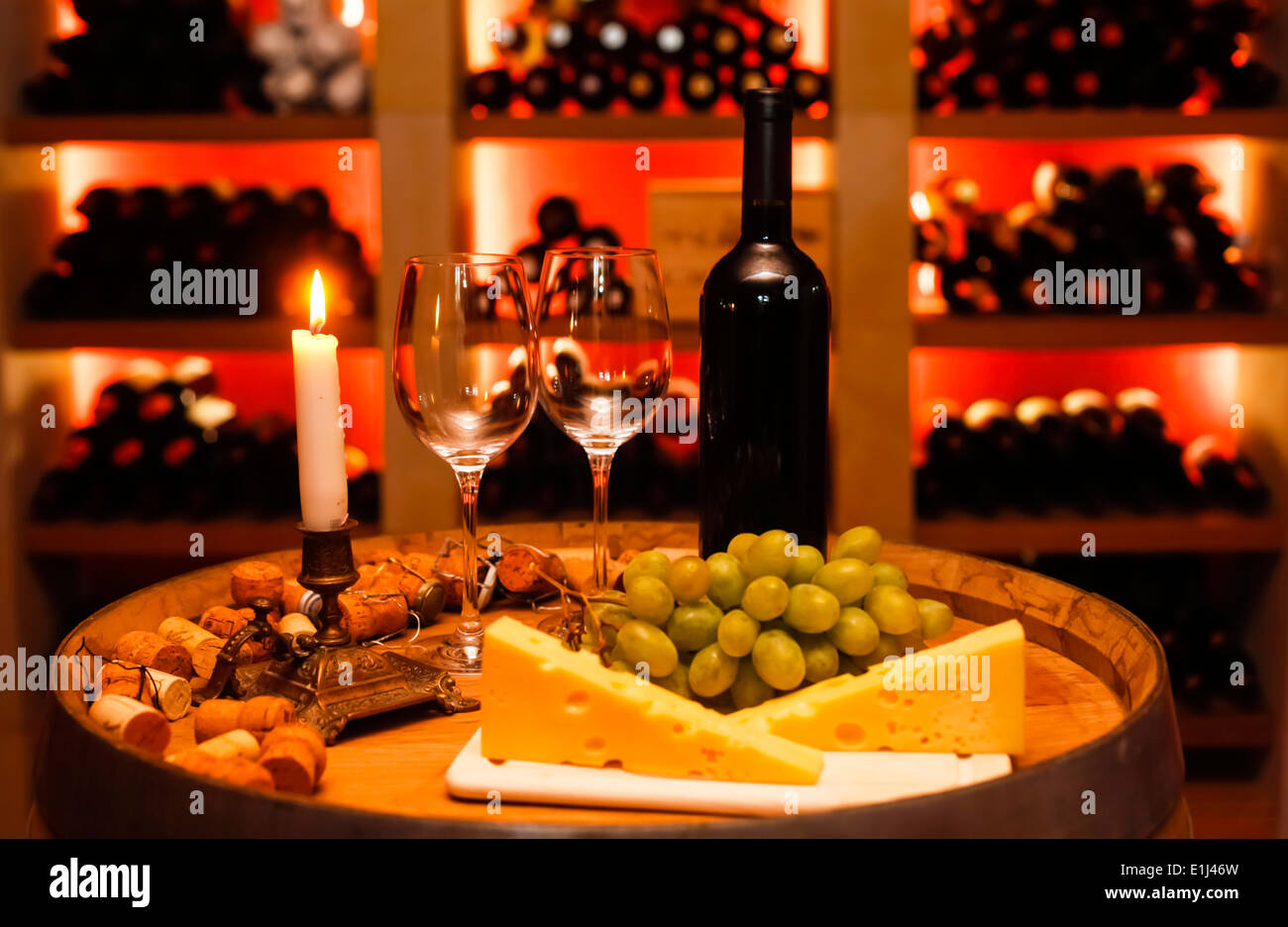 Private wine cellar with bottle of red wine, two wine glasses, grapes