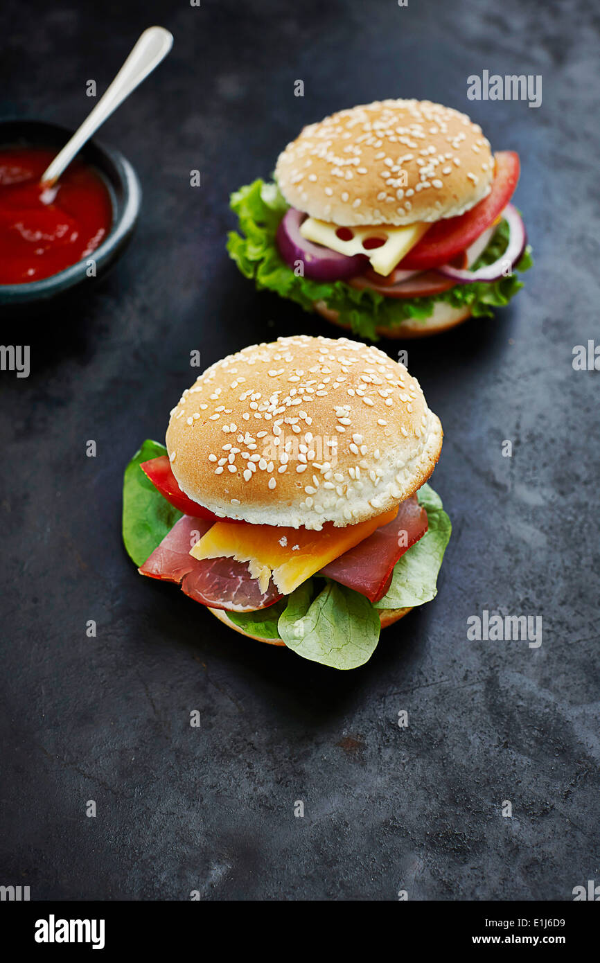 Two prepared burgers, mustard and ketchup on dark ground Stock Photo Alamy