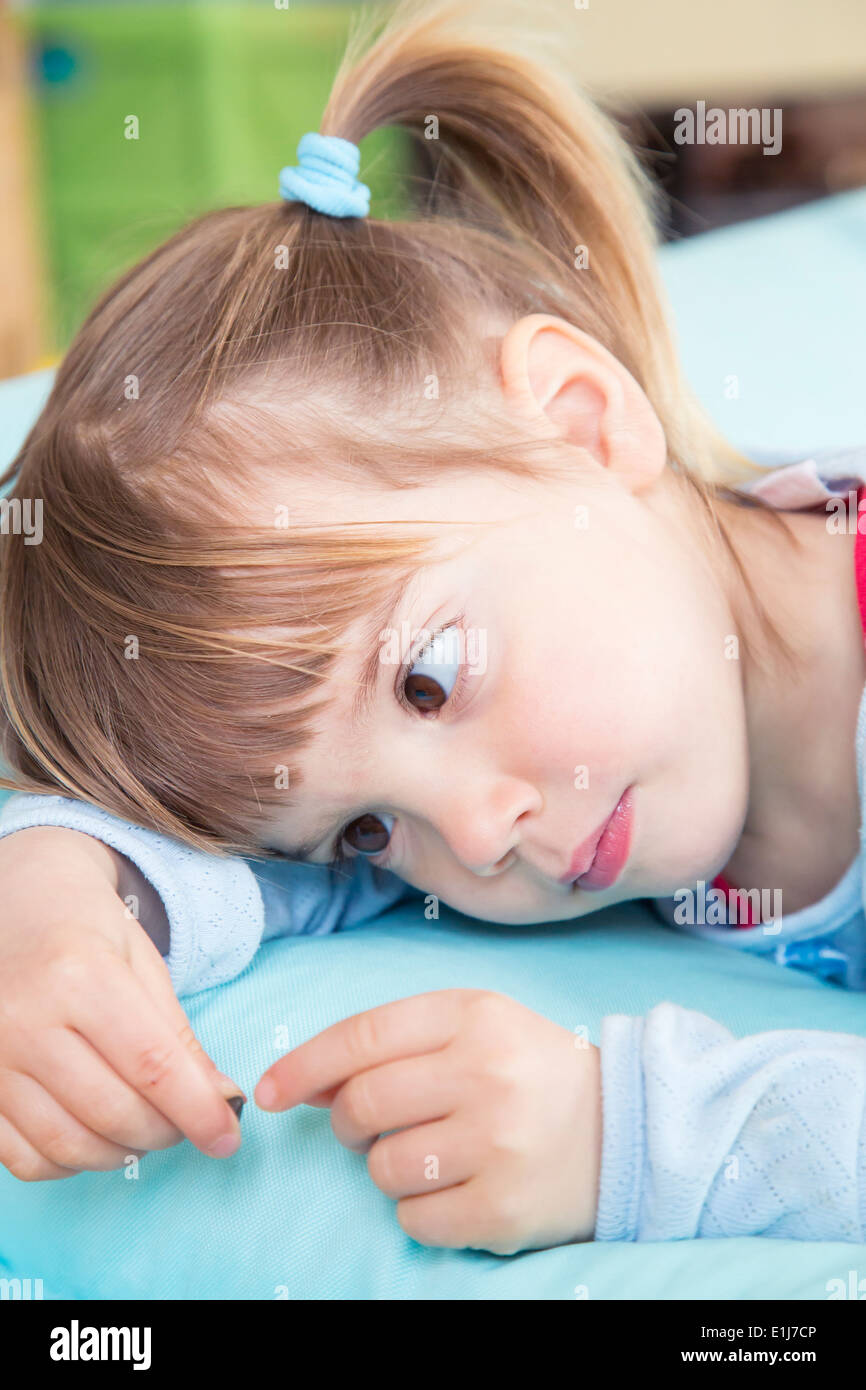 Portrait of little girl lying on bean bag Stock Photo - Alamy