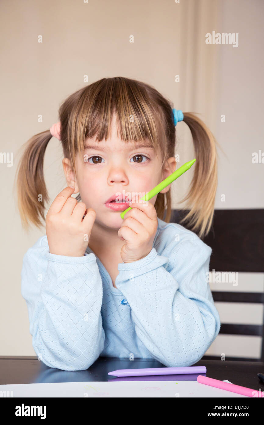 Portrait of pensive little girl with wax crayons Stock Photo - Alamy