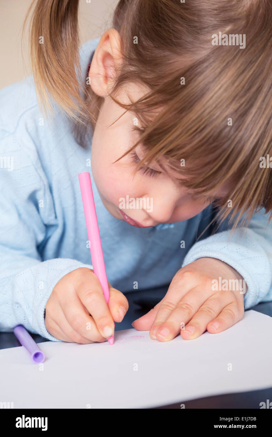 Portrait of little girl painting with wax crayons Stock Photo - Alamy