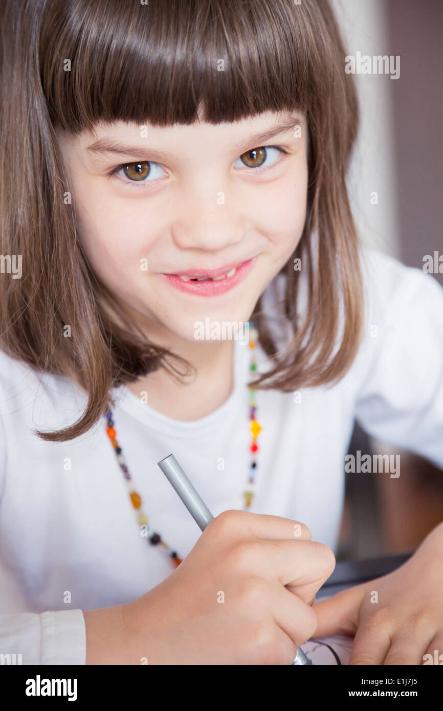Portrait of smiling little girl painting with wax crayon Stock Photo ...