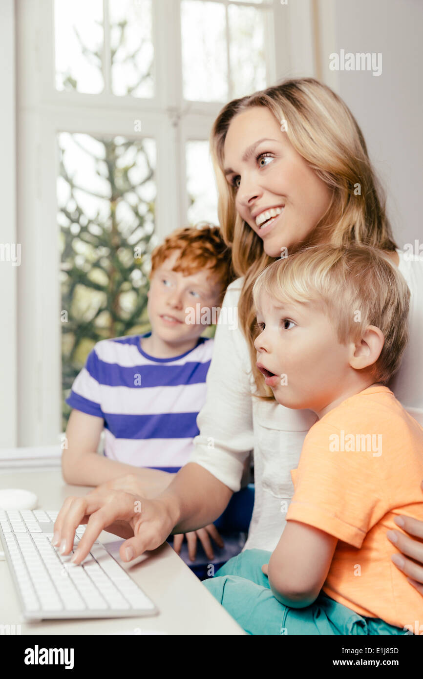Happy mother with two sons looking at computer screen Stock Photo