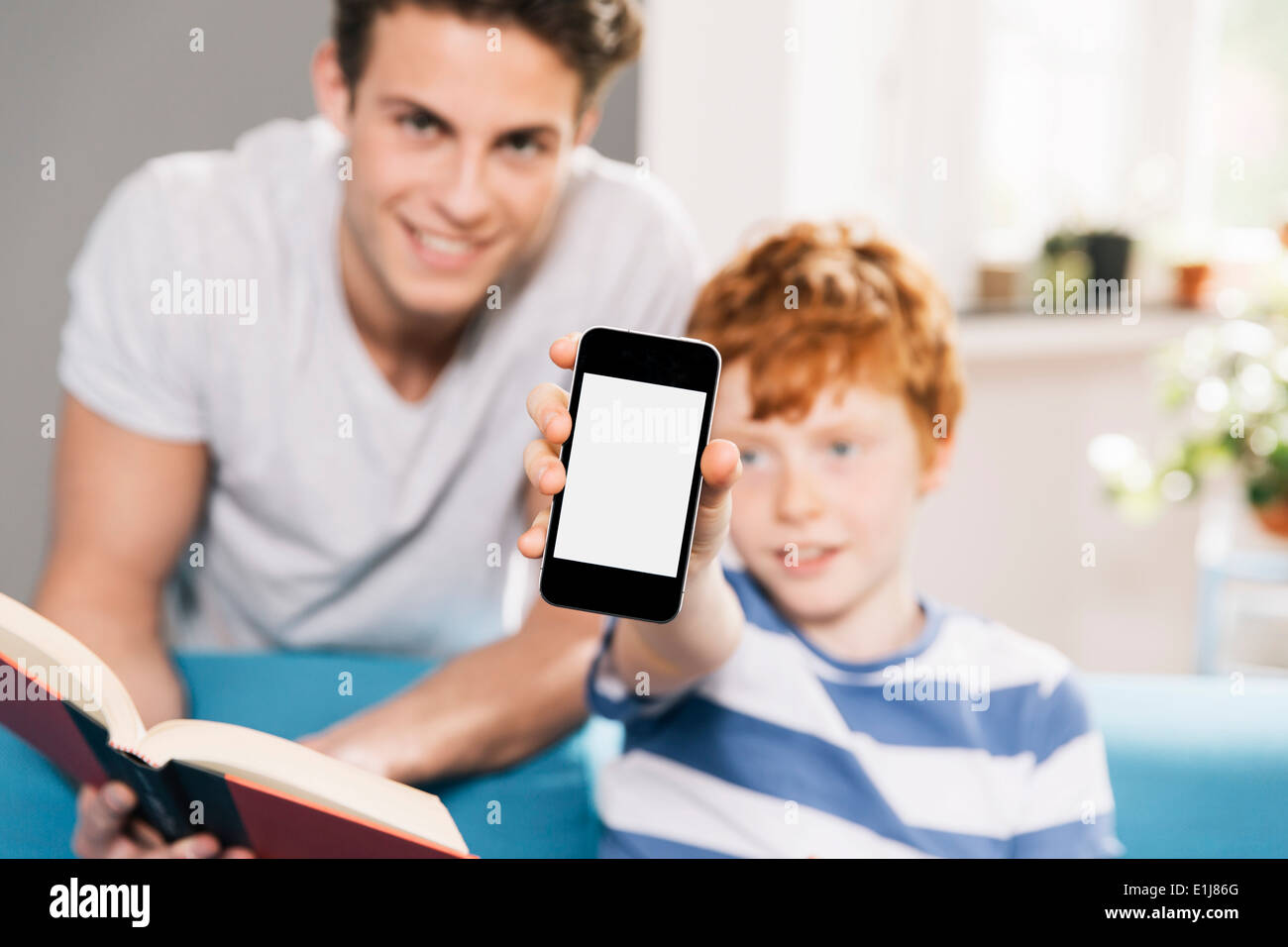 Father and son with book and smartphone Stock Photo