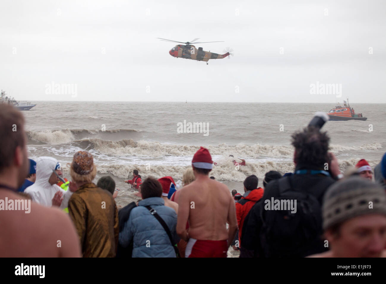 Crowd watching emergency helicopter and lifeboat  at Polar Bear Club New Year's Day plunge, Ostend, Belgium Stock Photo