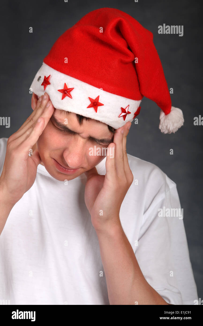 Painful Teenager in Santas Hat Stock Photo