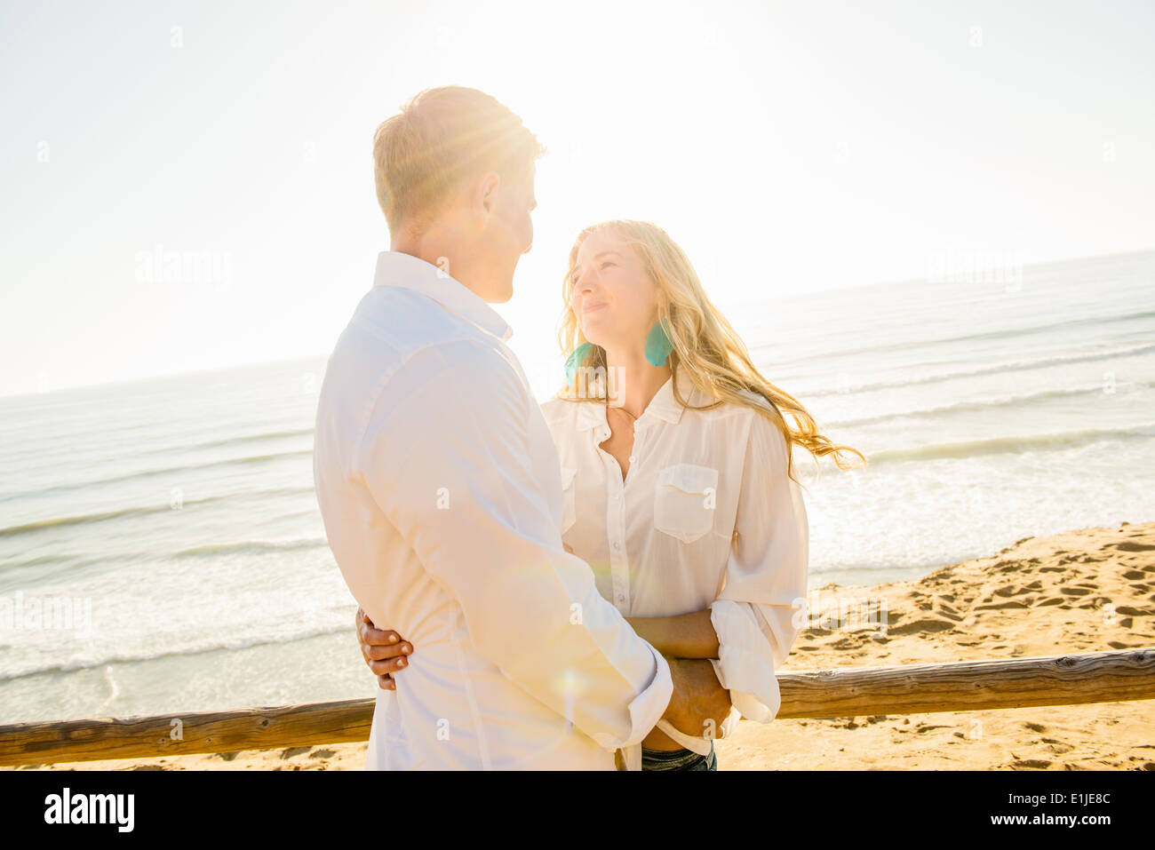 Romantic young couple with arms around each other at coast Stock Photo