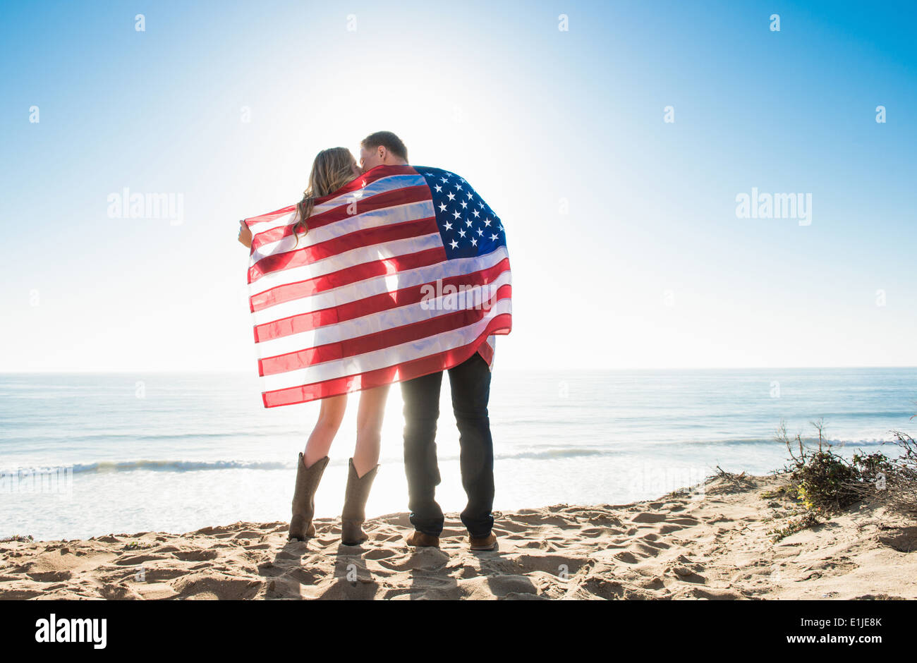 Romantic young couple wrapped in american flag, Torrey Pines, San Diego, California, USA Stock Photo