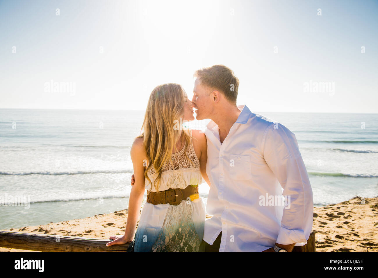 Romantic young couple sharing a kiss at coast Stock Photo