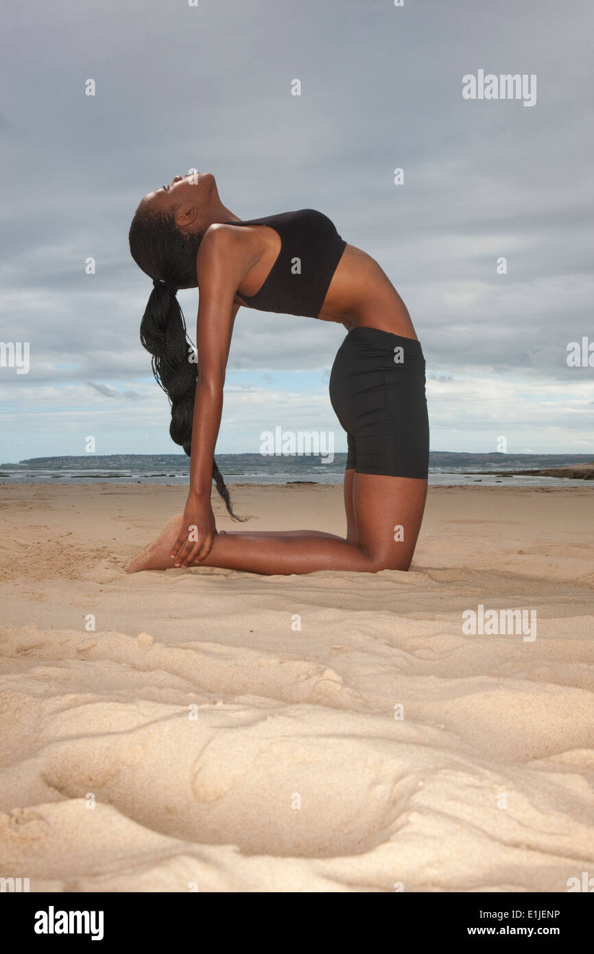 Woman kneeling on sand at a beach hi-res stock photography and images ...
