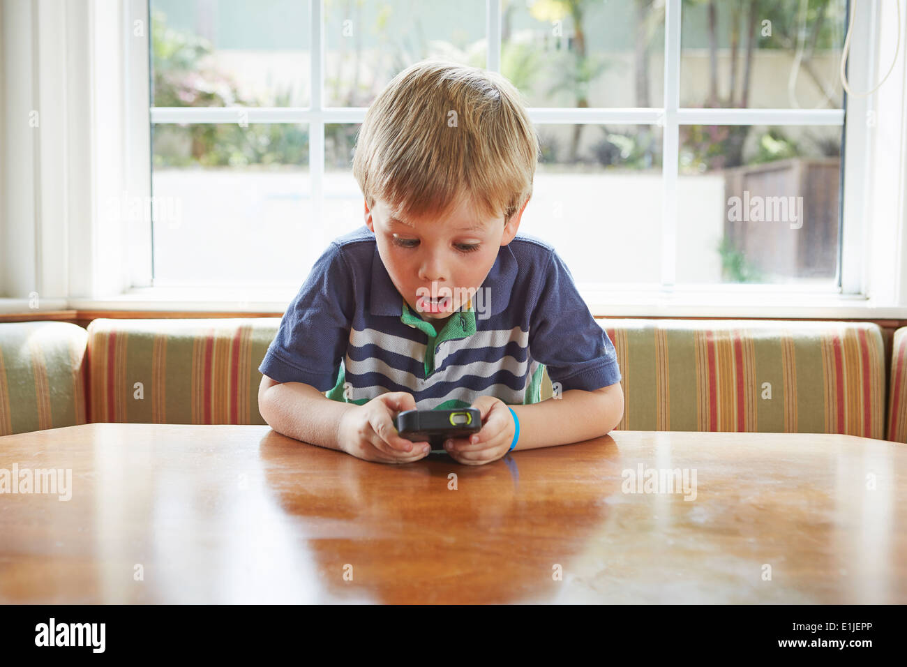 Boy playing handheld video game Stock Photo