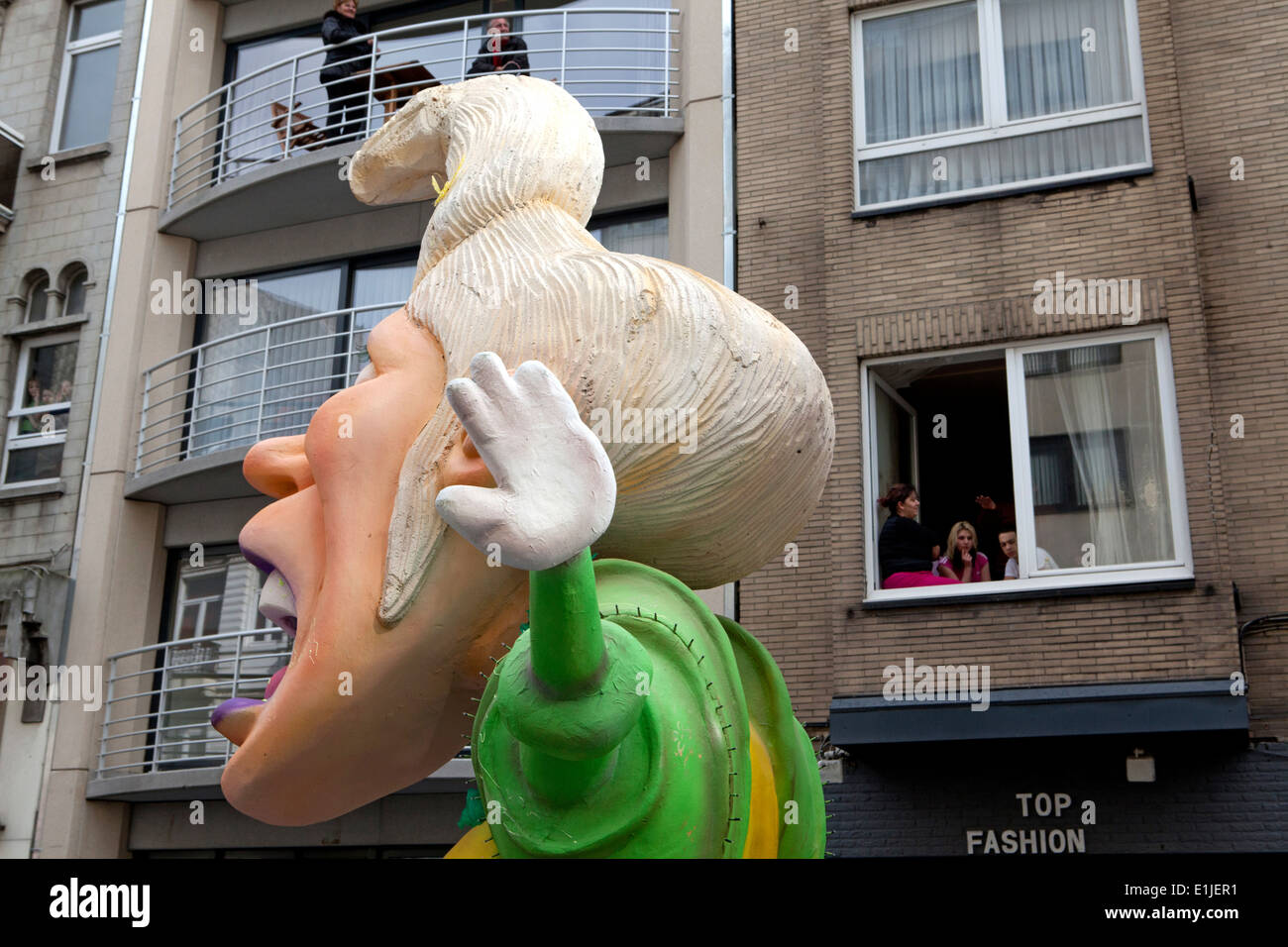 Effigy in Aalst carnival, residents watching from windows of apartment block, Aalst, Belgium Stock Photo