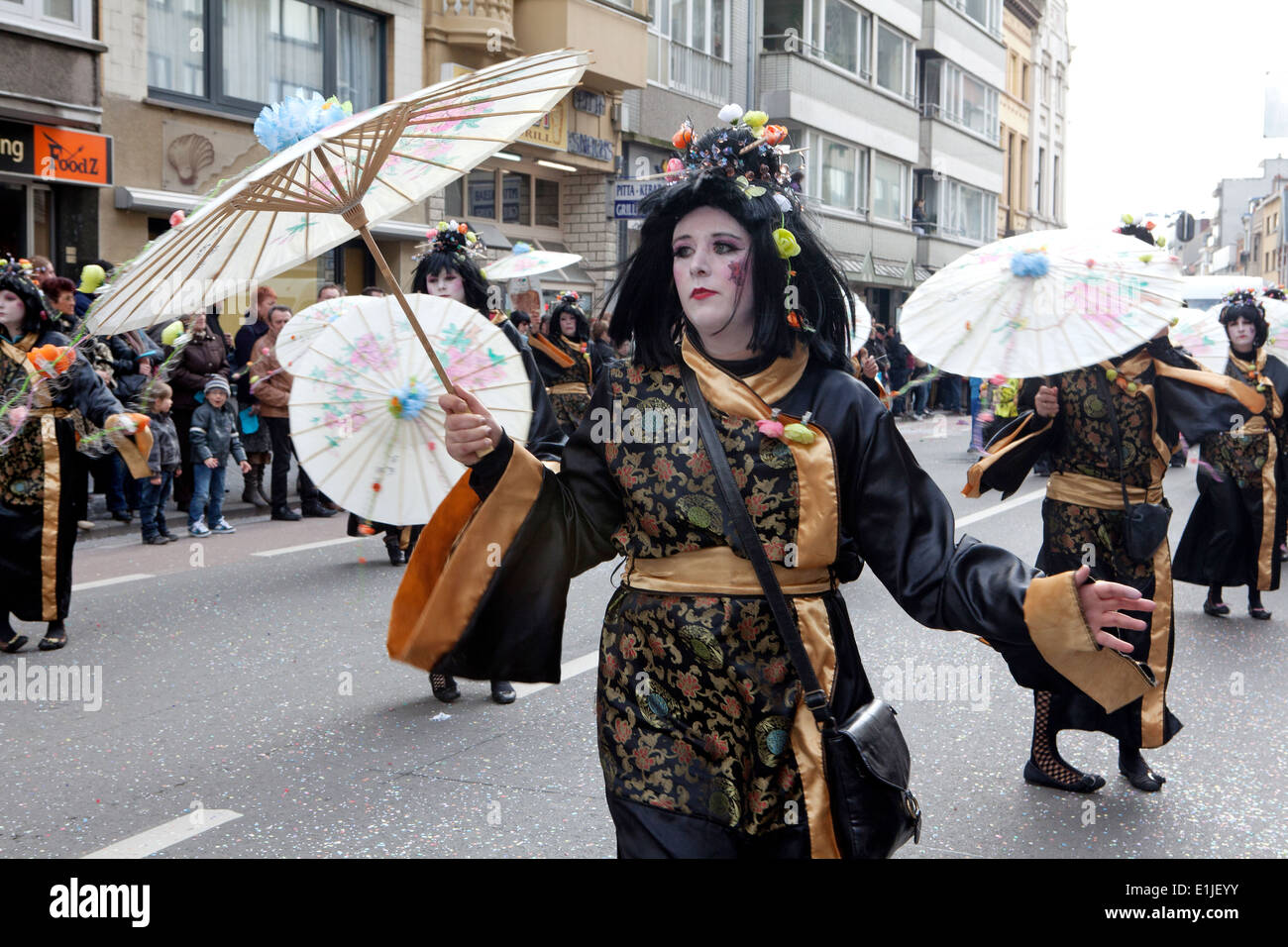 Parade dancing in street in traditional Japanese costumes with parasols, Ostend Carnival, Belgium Stock Photo