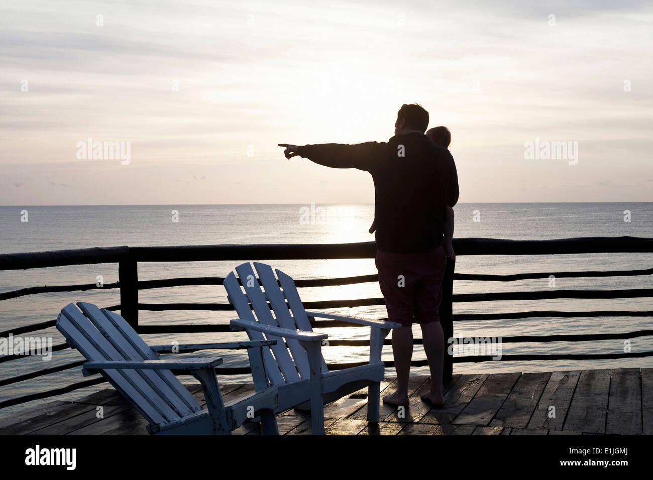 Father holding daughter and pointing out to sea in Tulum, Mexico Stock Photo