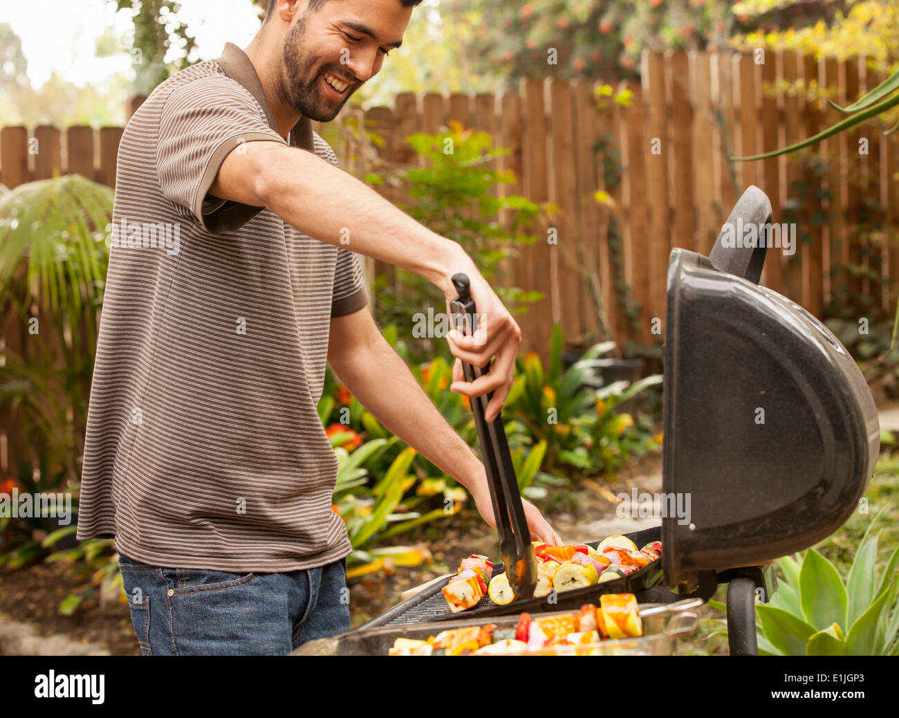Man cooking vegetable skewers on barbecue Stock Photo Alamy