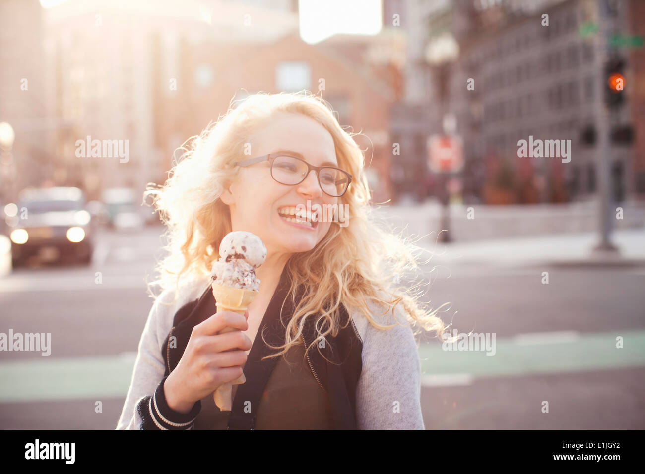 Young woman eating ice cream in street Stock Photo