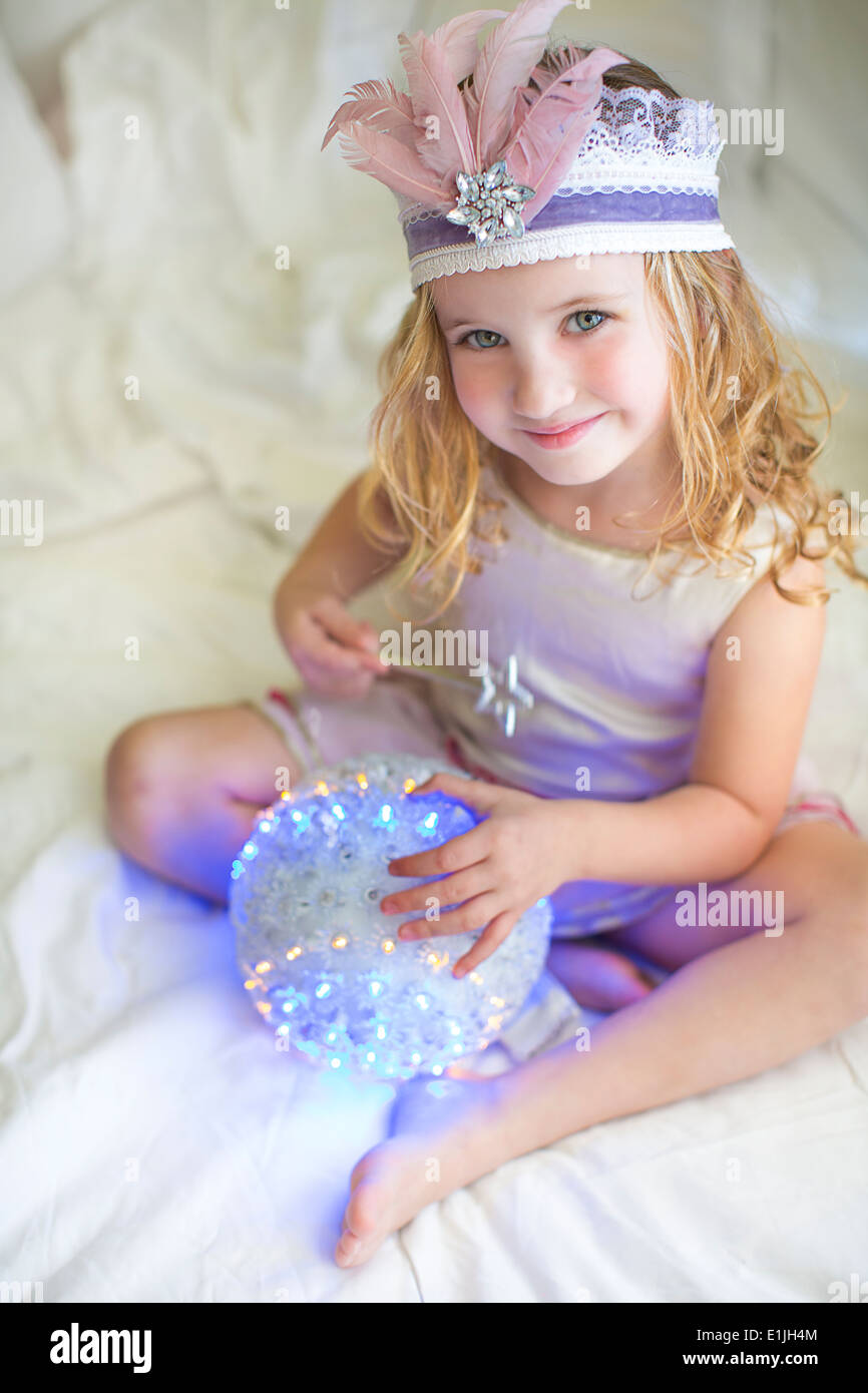 Portrait of young girl in fairy costume on bed Stock Photo