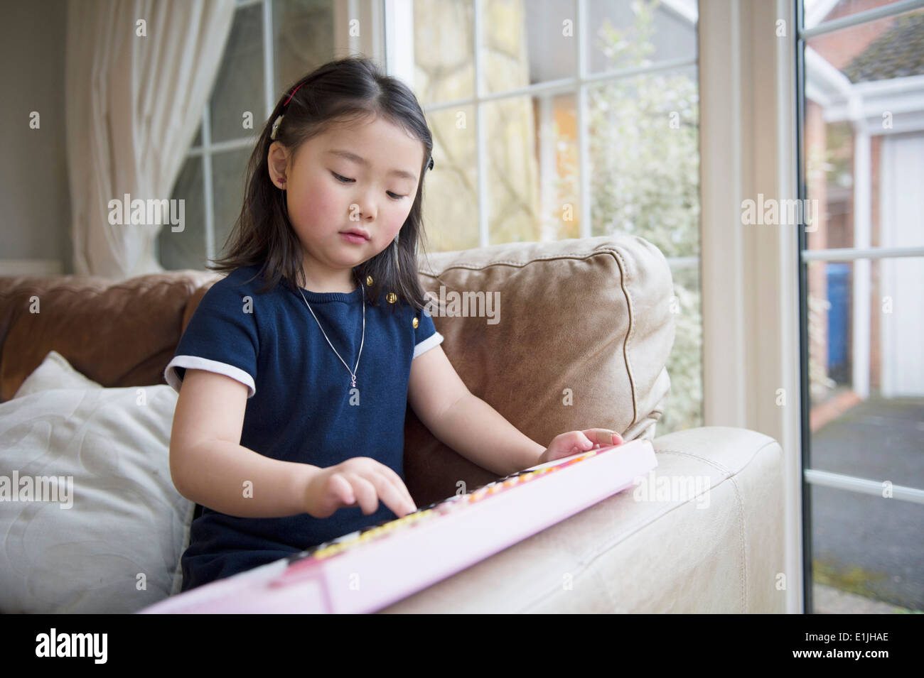 Girl playing toy keyboard Stock Photo