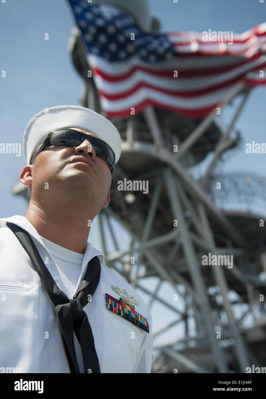A U.S. Sailor mans the rails aboard the amphibious dock landing ship