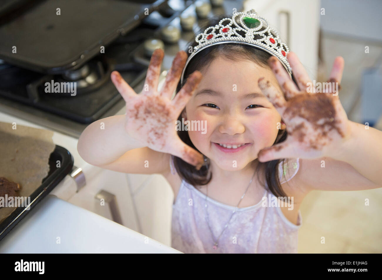 Girl with dirty hands, wearing crown Stock Photo