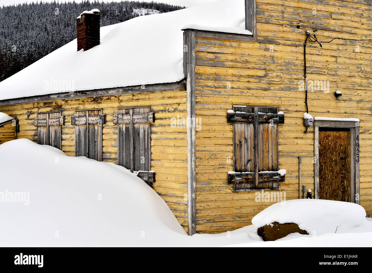 A section view of an old building standing under the heavy winter snow Stock Photo