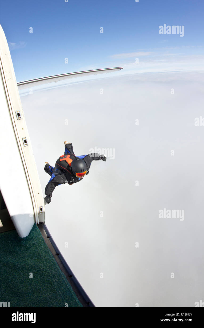 Mid adult man mid air preparing to fly in wingsuit Stock Photo
