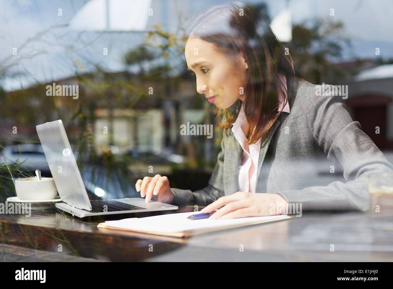Young female businesswoman using laptop in cafe Stock Photo