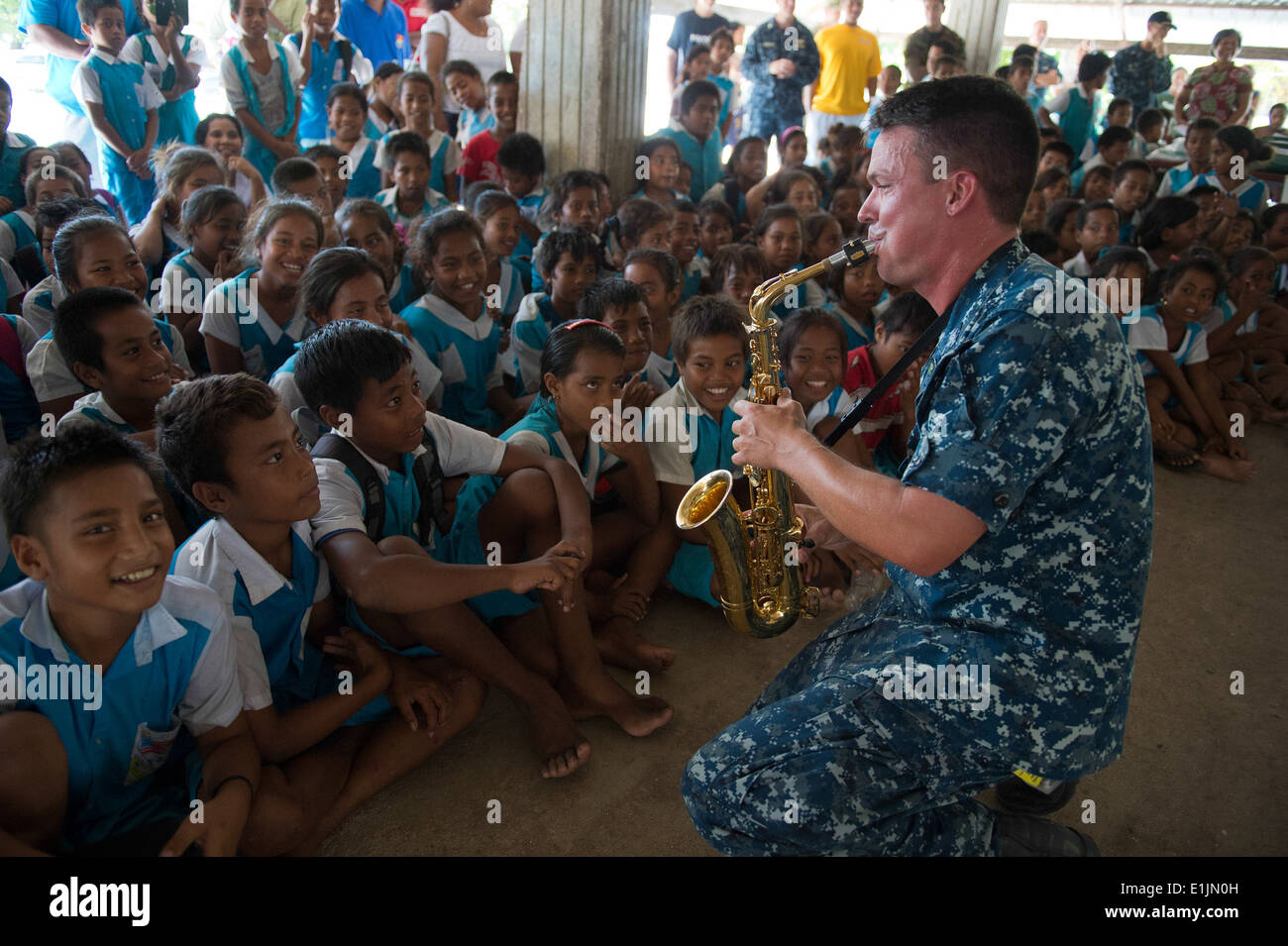 U.S. Navy Musician 1st Class Gresh Laing, right, performs for students during a community service project for Pacific Partnersh Stock Photo