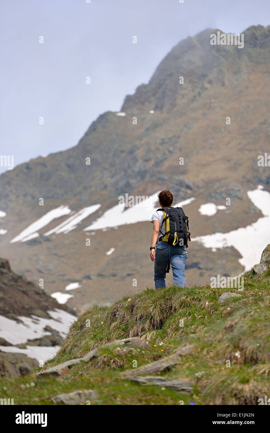 Female hiker with backpack walking in the italian Alps Stock Photo - Alamy