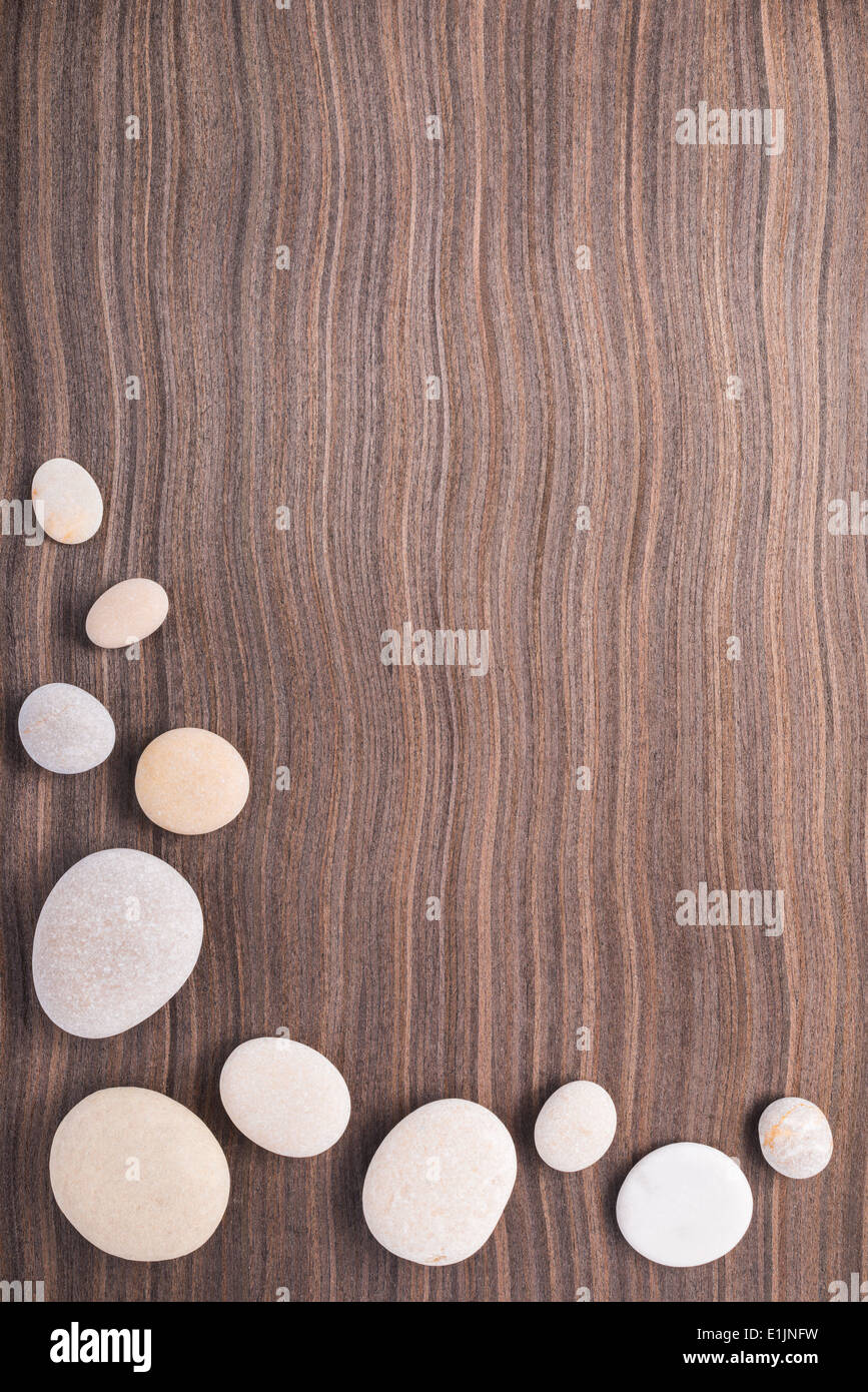 light pebbles on wooden ebony tree background Stock Photo