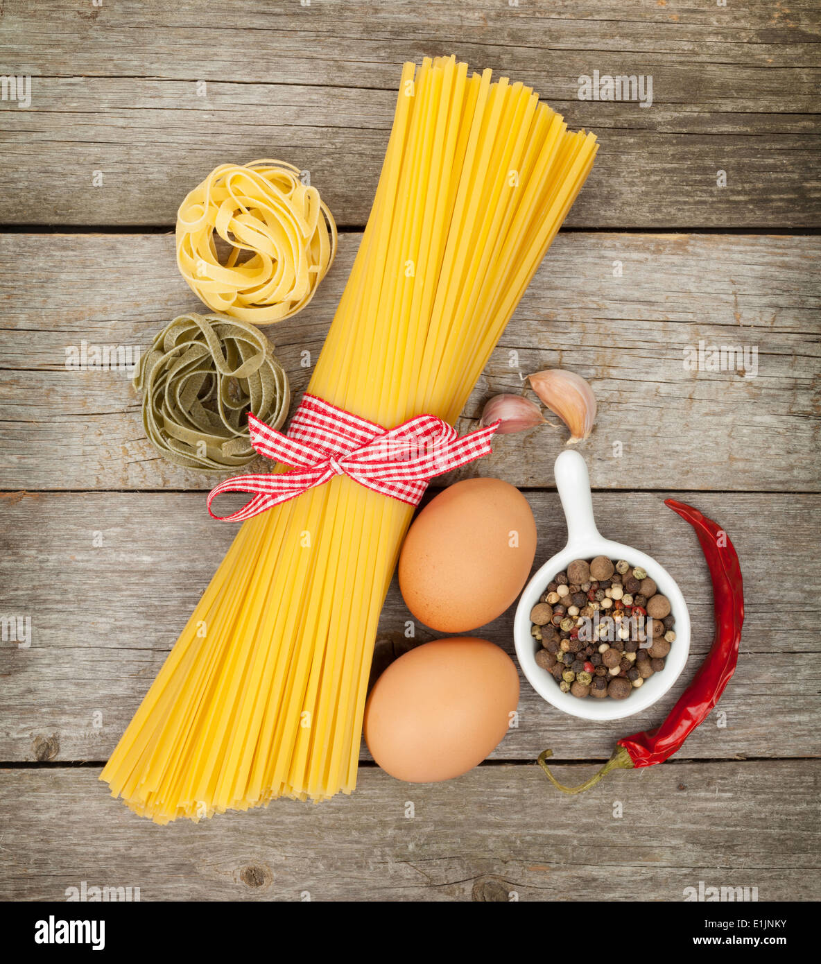 Pasta, eggs and spices on wooden table background Stock Photo